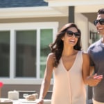 young couple standing near new home real estate concept